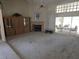 Spacious living room featuring neutral carpeting, a fireplace, and sliding glass doors to the outside at 9168 Southern Comfort Ct, Weeki Wachee, FL 34613