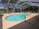 Relax in this screened-in pool featuring a unique design, perfect for cooling off on warm days at 9168 Southern Comfort Ct, Weeki Wachee, FL 34613