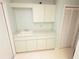Functional laundry room with sink, counter, and ample cabinet space for organization and storage at 9168 Southern Comfort Ct, Weeki Wachee, FL 34613
