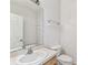 Well-lit bathroom with a white sink, toilet, and a large mirror reflecting the shower and tub area at 9420 Georgian Park Ln # 106, Tampa, FL 33626