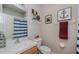 Bright bathroom featuring a white sink, toilet, blue striped shower curtain and nautical-themed decor at 9420 Georgian Park Ln # 106, Tampa, FL 33626