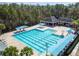 Aerial view of a community pool with lap lanes, lounge area, and covered seating, all surrounded by green space at 9420 Georgian Park Ln # 106, Tampa, FL 33626