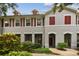 Charming townhouse exterior with red shutters, covered porch, and landscaped front yard at 9420 Georgian Park Ln # 106, Tampa, FL 33626