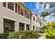 Side view of a gray townhouse with red shutters and a landscaped walkway at 9420 Georgian Park Ln # 106, Tampa, FL 33626