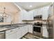 Well-lit kitchen with stainless steel appliances, granite countertops, and white cabinets at 9420 Georgian Park Ln # 106, Tampa, FL 33626