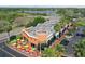 Aerial shot of a restaurant with outdoor seating under colorful umbrellas and ample parking by a lake at 9420 Georgian Park Ln # 106, Tampa, FL 33626