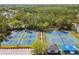 Aerial view of a community's tennis courts complex surrounded by trees, offering many courts for play at 9420 Georgian Park Ln # 106, Tampa, FL 33626