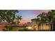 Stunning Mediterranean style home with red tile roof, lush landscaping, and a picturesque sunset backdrop at 9829 Sorbonne Loop, Seffner, FL 33584