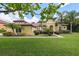 Beautiful Mediterranean-style home with a lush green lawn, meticulously manicured landscaping, and a charming architectural design at 9829 Sorbonne Loop, Seffner, FL 33584
