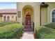 Charming front entrance with red door, brick walkway, manicured hedges, and an elegant number plaque at 9829 Sorbonne Loop, Seffner, FL 33584