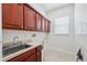 Functional laundry room with abundant cabinet space, a sink, and a window for natural light at 9829 Sorbonne Loop, Seffner, FL 33584