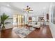 Bright living room with a ceiling fan, hardwood floors, and open layout leading into the kitchen at 9829 Sorbonne Loop, Seffner, FL 33584