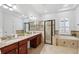 Spacious main bathroom with a double sink vanity, a glass shower, and soaking tub at 9829 Sorbonne Loop, Seffner, FL 33584