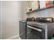Laundry room with modern washer and dryer and shelving above for storage at 10435 Peppergrass Ct, Trinity, FL 34655