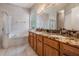 Main bathroom featuring double sinks, granite counters, tub, and a walk-in shower at 10435 Peppergrass Ct, Trinity, FL 34655