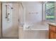 Bathroom featuring a glass shower and garden tub at 10435 Peppergrass Ct, Trinity, FL 34655