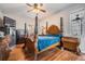 Main bedroom with wood floors, ceiling fan, and beautiful four poster bed at 10435 Peppergrass Ct, Trinity, FL 34655
