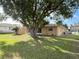 Spacious backyard with mature trees offering plenty of shade and privacy, with a screened-in porch at 10458 Clingman St, Spring Hill, FL 34608