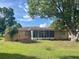 A spacious backyard offers mature trees and a cozy screened-in porch perfect for outdoor relaxation at 10458 Clingman St, Spring Hill, FL 34608