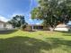 The ample backyard includes mature trees that provide shade and a screened-in porch for relaxation at 10458 Clingman St, Spring Hill, FL 34608