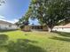 The large backyard features mature trees, a screened-in porch, and privacy provided by a fence at 10458 Clingman St, Spring Hill, FL 34608