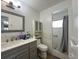 Modern bathroom with a gray vanity, tiled floors, and a shower with white subway tiles at 10458 Clingman St, Spring Hill, FL 34608