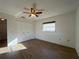 Well-lit bedroom with wood-look floors, a ceiling fan, and a closet for storage at 10458 Clingman St, Spring Hill, FL 34608