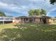 Traditional single story home with a large front yard and RV parked to the side of the home at 10458 Clingman St, Spring Hill, FL 34608