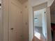Neutral hallway connecting to the bedroom, featuring hardwood floors and closet space at 10458 Clingman St, Spring Hill, FL 34608