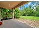 A covered back porch overlooks a spacious yard, surrounded by lush greenery and mature trees offering privacy at 10925 Oyster Bay Cir, New Port Richey, FL 34654