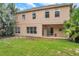 Exterior of home featuring a spacious backyard with a covered patio, windows, and lush tropical landscaping at 10925 Oyster Bay Cir, New Port Richey, FL 34654