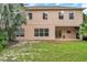 Backyard with a spacious lawn, covered patio, and a tan home exterior with well-placed windows at 10925 Oyster Bay Cir, New Port Richey, FL 34654