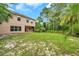 A large green backyard, perfect for outdoor activities, with a partially covered back porch at 10925 Oyster Bay Cir, New Port Richey, FL 34654