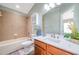 Inviting bathroom featuring wood-look floors, vanity with marble countertop, and bathtub with tile surround at 10925 Oyster Bay Cir, New Port Richey, FL 34654