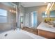 Bright bathroom featuring a soaking tub, glass-enclosed shower, and access to a walk-in closet at 10925 Oyster Bay Cir, New Port Richey, FL 34654