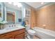 Bathroom with tile surround, wooden vanity, and cabinet at 10925 Oyster Bay Cir, New Port Richey, FL 34654