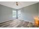 Inviting bedroom showcasing wood-look floors, multiple windows, and neutral paint creating a bright and open space at 10925 Oyster Bay Cir, New Port Richey, FL 34654