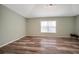 A spacious bedroom with wood-look flooring, a window, and track lighting at 10925 Oyster Bay Cir, New Port Richey, FL 34654