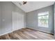 Bedroom with wood floors, closet, and natural light from the window at 10925 Oyster Bay Cir, New Port Richey, FL 34654