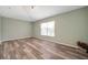 A spacious bedroom with wood-look flooring, a window, and track lighting at 10925 Oyster Bay Cir, New Port Richey, FL 34654