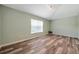 A spacious bedroom with wood-look flooring, a window, and track lighting at 10925 Oyster Bay Cir, New Port Richey, FL 34654