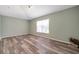 Well-lit bedroom showcasing wood-look floors, a large window, and neutral paint, creating a cozy atmosphere at 10925 Oyster Bay Cir, New Port Richey, FL 34654