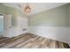 Inviting bedroom featuring wood-look floors, wainscoting detail, and a closet for additional storage at 10925 Oyster Bay Cir, New Port Richey, FL 34654
