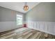 Bright bedroom featuring wood-look floors, decorative wall trim, and ample natural light for a cozy feel at 10925 Oyster Bay Cir, New Port Richey, FL 34654