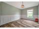 Comfortable bedroom showcasing wood-look floors, decorative wall trim, and ample natural light, creating a serene space at 10925 Oyster Bay Cir, New Port Richey, FL 34654