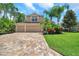 Inviting two-story home with a three-car garage, brick paver driveway, and mature tropical landscaping at 10925 Oyster Bay Cir, New Port Richey, FL 34654