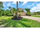 Beautiful home featuring mature palm trees, lush green grass and landscaping adding a touch of nature at 10925 Oyster Bay Cir, New Port Richey, FL 34654