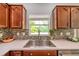Kitchen sink with stainless steel hardware, tile backsplash, and bright window at 10925 Oyster Bay Cir, New Port Richey, FL 34654