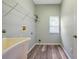 Laundry room with utility sink, shelving, and a window for natural light at 10925 Oyster Bay Cir, New Port Richey, FL 34654