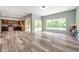 Open concept living room with wood-look flooring, sliding glass doors, and ample natural light at 10925 Oyster Bay Cir, New Port Richey, FL 34654